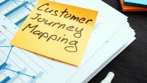 en la imagen muestra un cuaderno con un post diciendo customer journey mappping